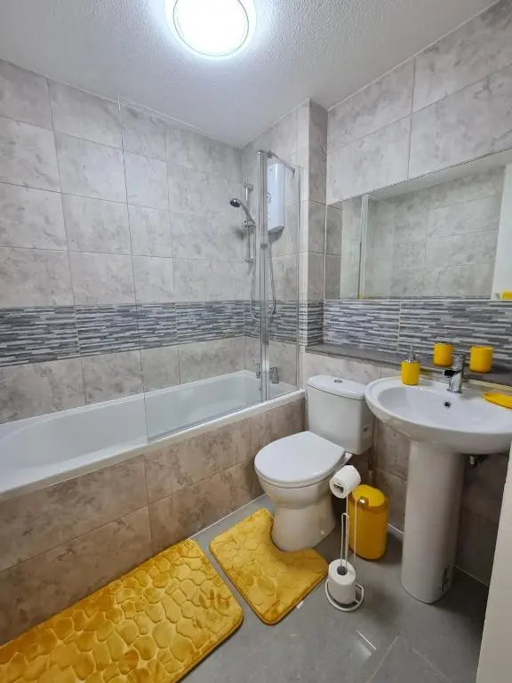 a bathroom with a toilet and a sink and a tub at Lovely 2 bedroom flat in nice Inversness area. in Inverness