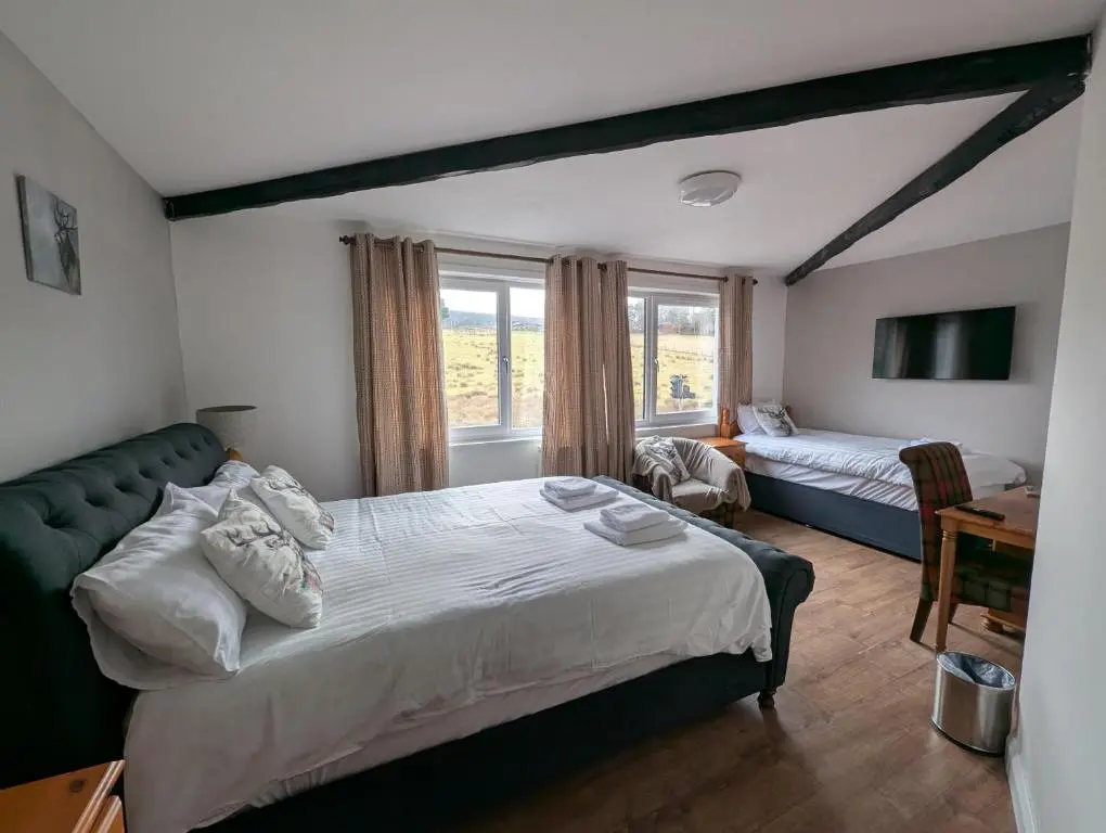 a bedroom with a large bed and a desk at Old North Inn Hotel in Kirkhill