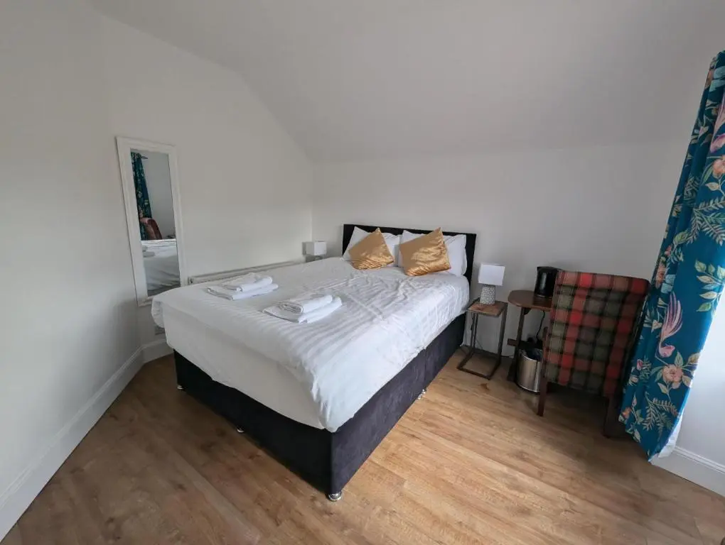 a bedroom with a bed and a chair in it at Old North Inn Hotel in Kirkhill