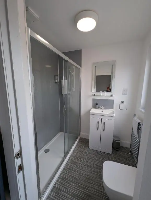 a bathroom with a shower and a toilet and a sink at Old North Inn Hotel in Kirkhill