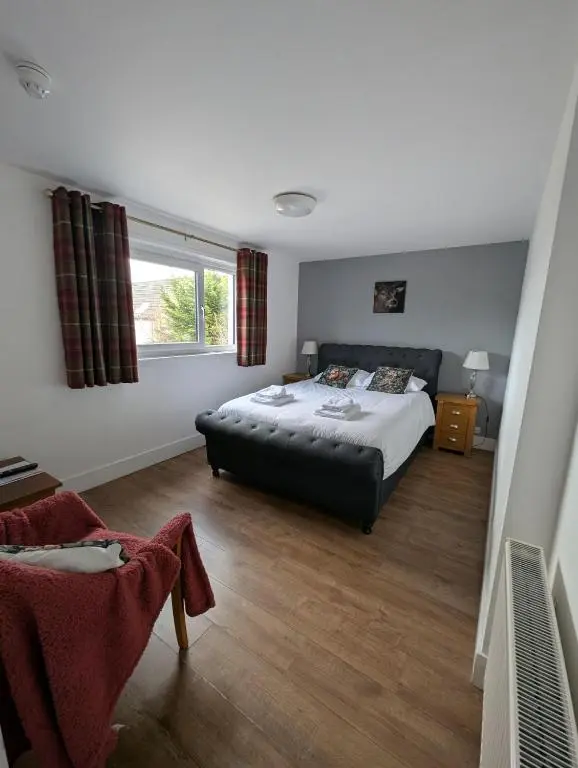 a bedroom with a bed and a large window at Old North Inn Hotel in Kirkhill