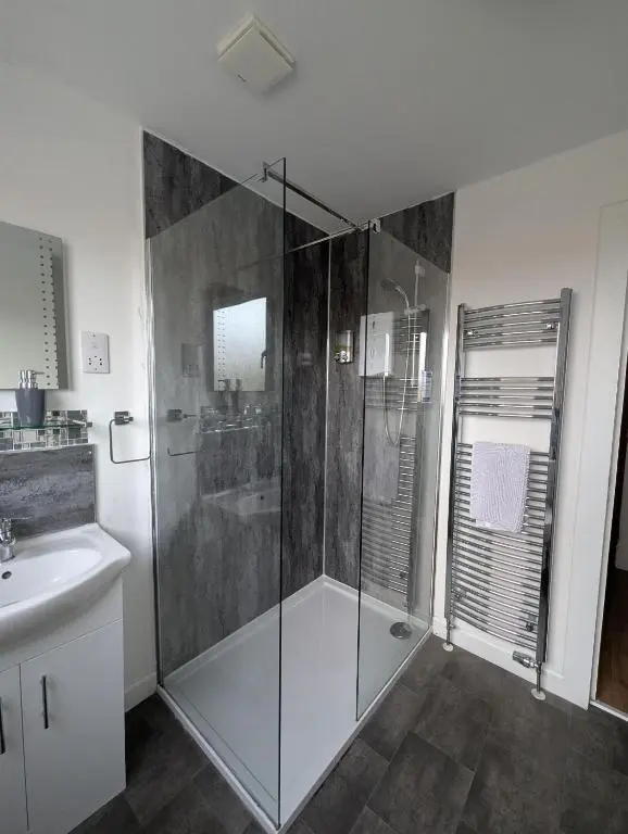 a bathroom with a glass shower and a sink at Old North Inn Hotel in Kirkhill