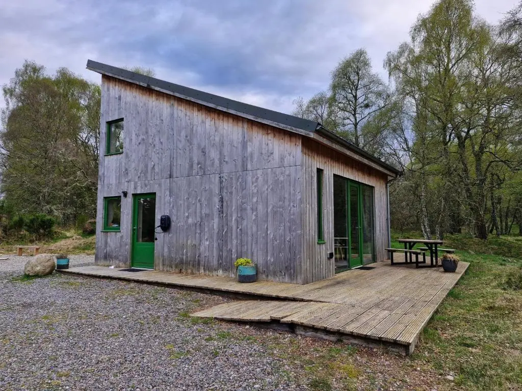 a small shed with a wooden deck and a picnic table at Betula Chalet \u2013 coast & country in the Highlands in Nairn