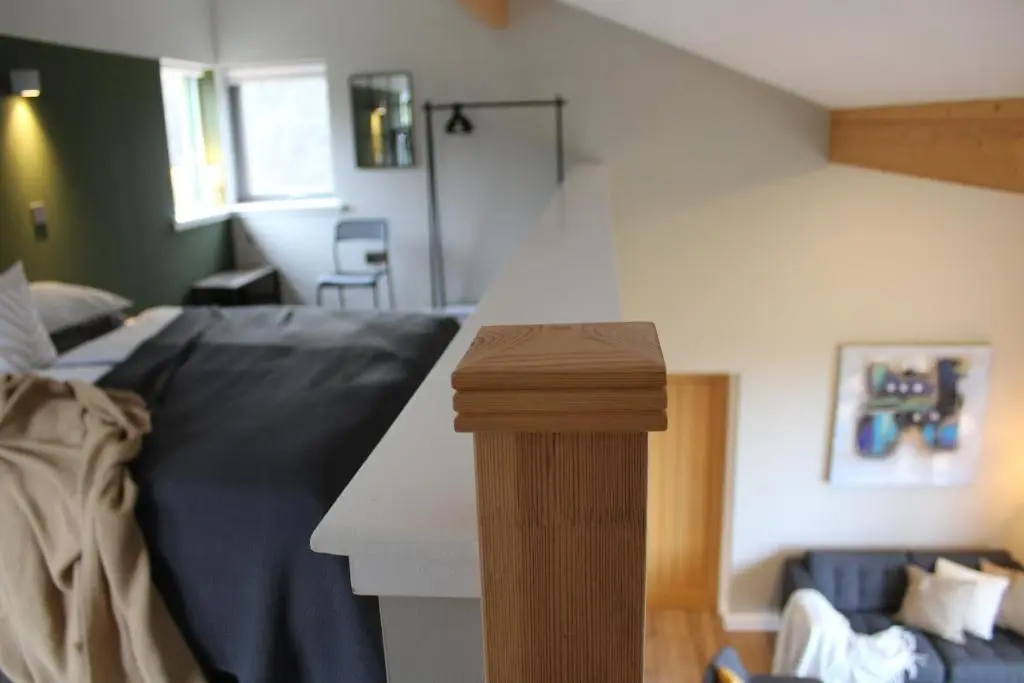 a living room with a bed and a stair case at Betula Chalet \u2013 coast & country in the Highlands in Nairn