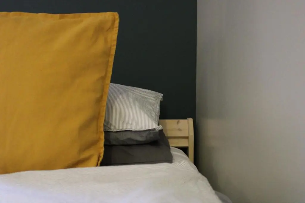 a bedroom with a bed with a yellow pillow at Betula Chalet \u2013 coast & country in the Highlands in Nairn