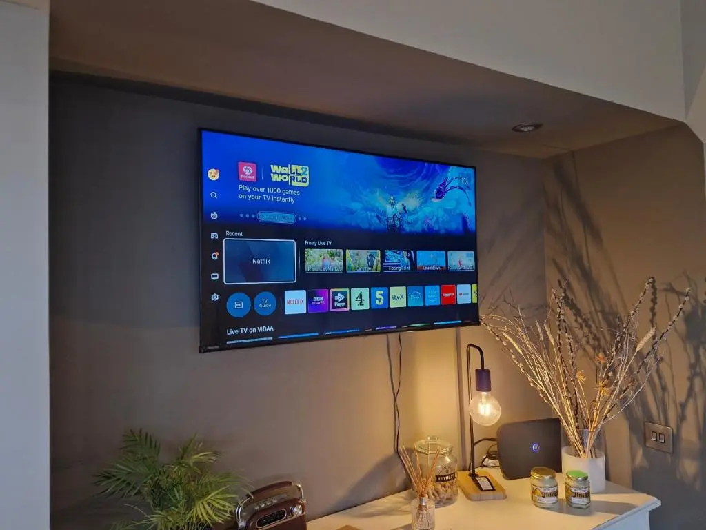 a flat screen tv hanging on a wall at Betula Chalet \u2013 coast & country in the Highlands in Nairn