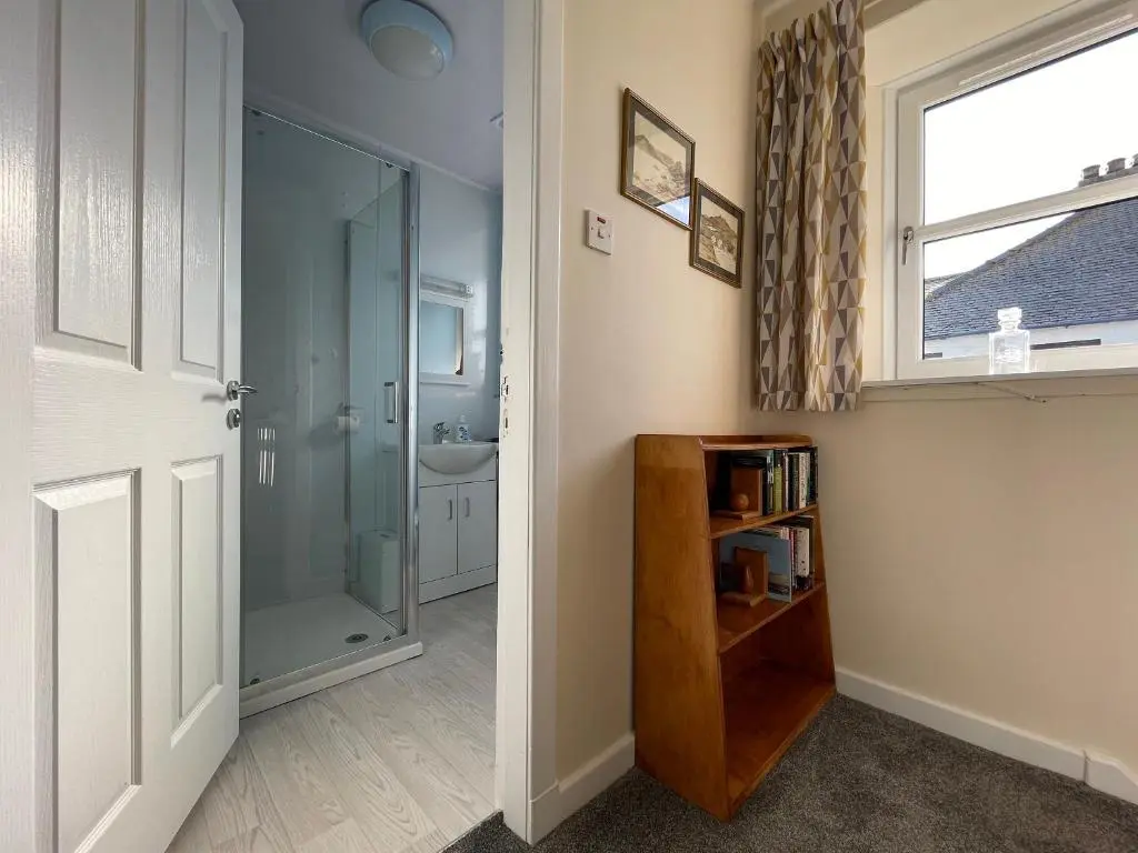 a bathroom with a shower and a glass door at Harbour Street in Portmahomack