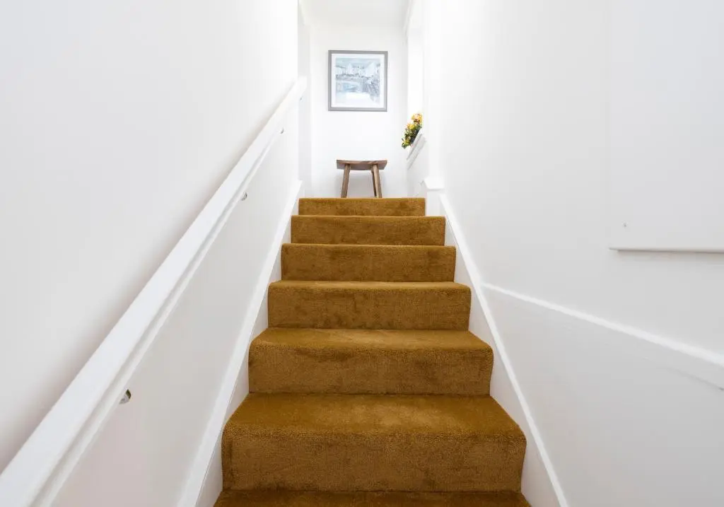 a stairway with a brown carpeted stair case at Aurora House Hot Tub & Sea View in Buckie