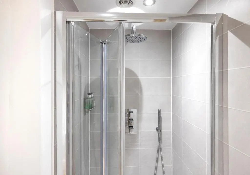 a shower with a glass door in a bathroom at Aurora House Hot Tub & Sea View in Buckie