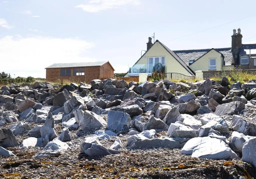 a pile of rocks in front of a house at Aurora House Hot Tub & Sea View in Buckie