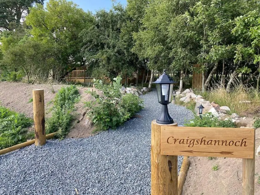 a sign for a garden with a light on it at Craigshannoch Luxury 1 bed woodland lodge hot tub in Kintore