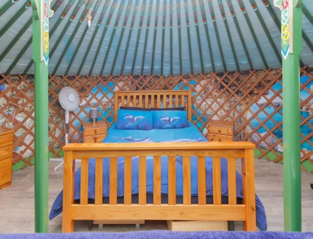 a wooden bed in a gazebo with at Green Yurt with Hot Tub - Sleeps 3 Parking & Pets in Turriff