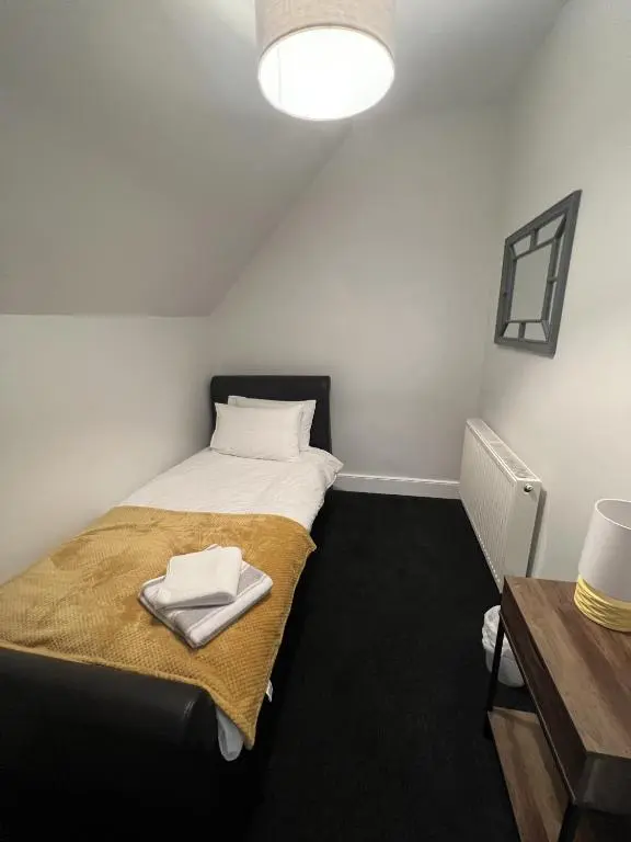 a small room with a bed and a desk at mySTAYINN Tomnahurich 3 Bedroom House in Inverness
