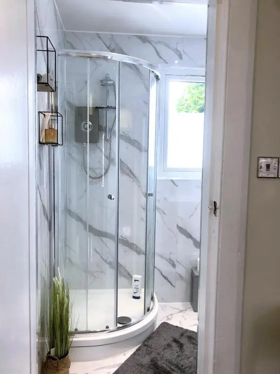 a shower with a glass door in a bathroom at mySTAYINN Tomnahurich 3 Bedroom House in Inverness