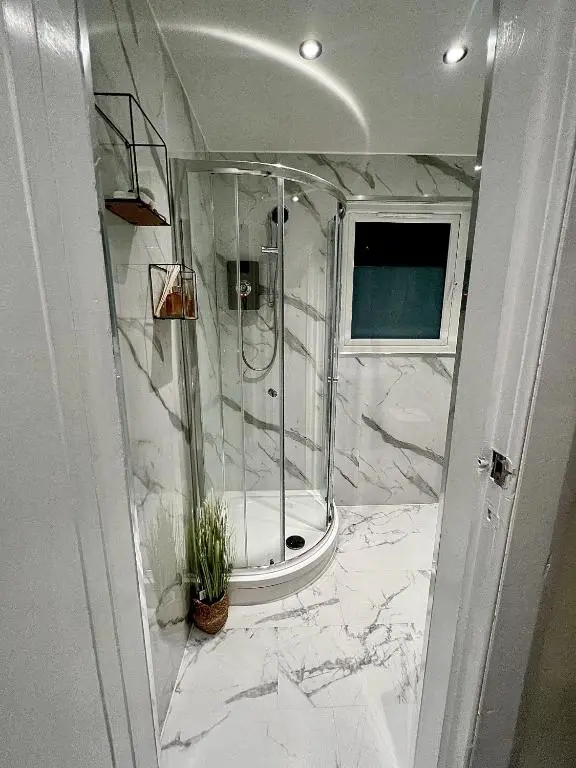 a marble bathroom with a shower and a tub at mySTAYINN Tomnahurich 3 Bedroom House in Inverness