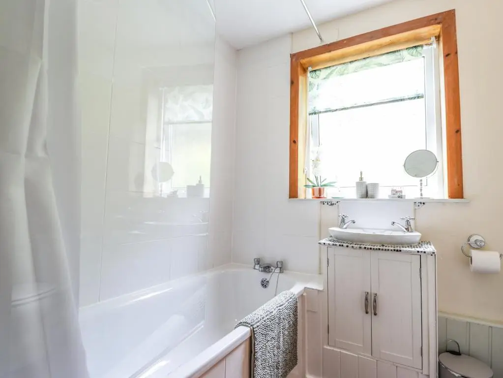 a bathroom with a sink and a tub and a window at Ceol na Mara in Berriedale