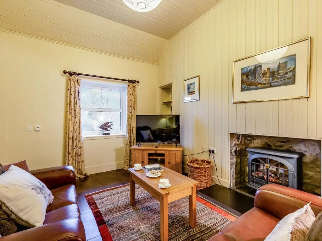 a living room with a couch and a fireplace at Allt Na Criche - Ukc5762 in Laggan