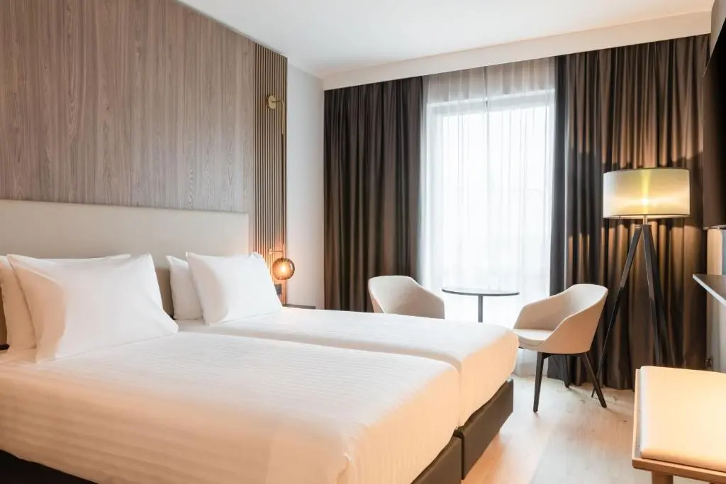 a hotel room with a large bed and a table at AC Hotel by Marriott Inverness in Inverness