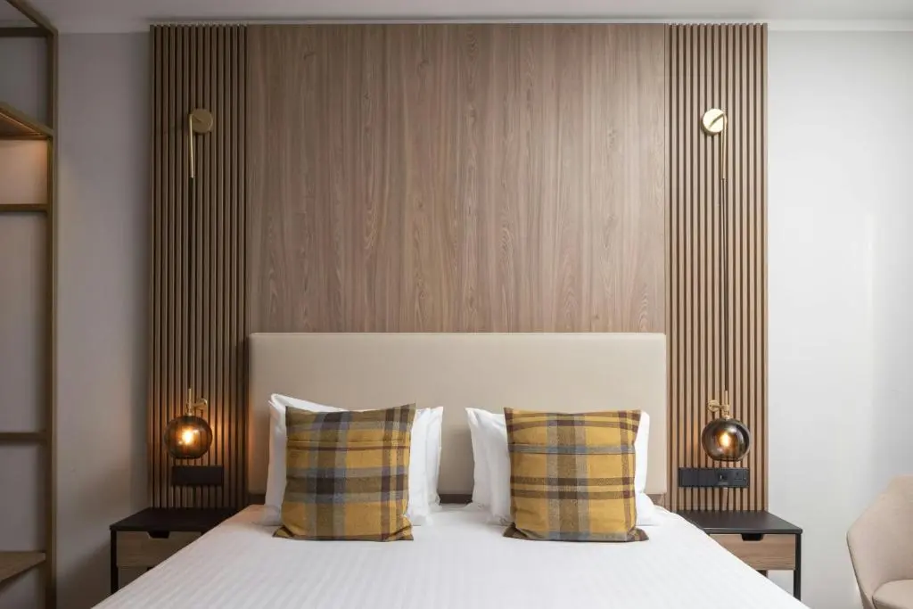 a bedroom with a white bed with two pillows at AC Hotel by Marriott Inverness in Inverness