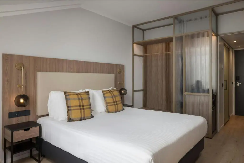 a bedroom with a large white bed with pillows at AC Hotel by Marriott Inverness in Inverness