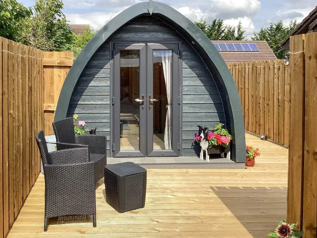 a dog sitting in a gazebo on a patio at The Dalmore Pod in Alness