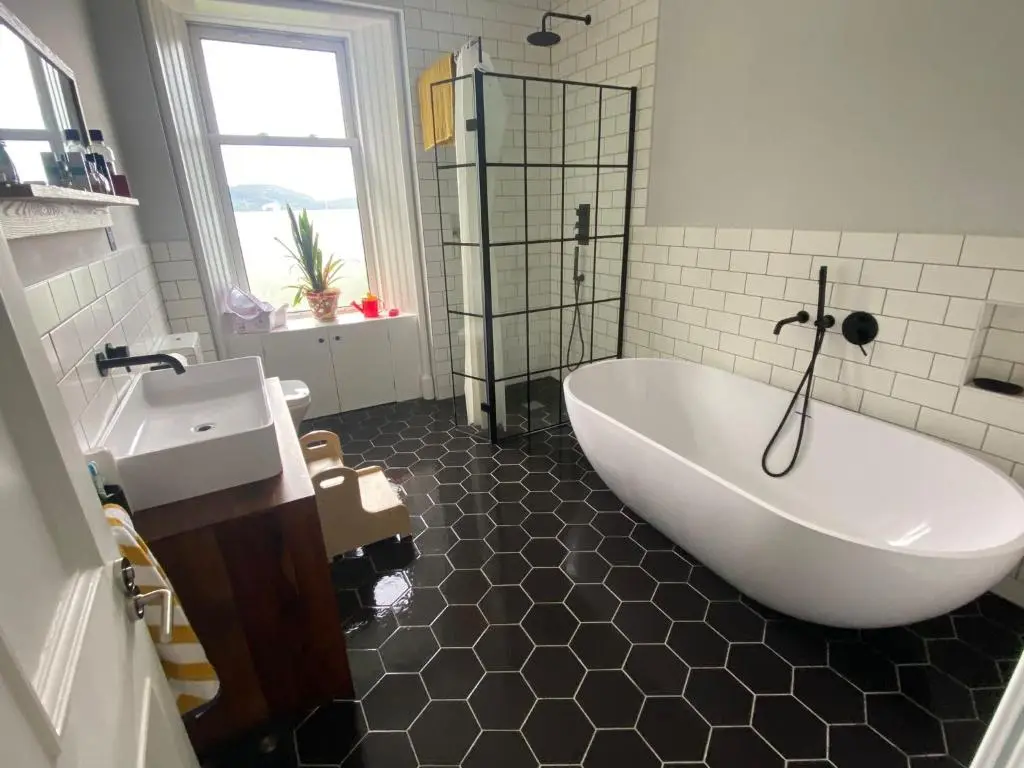 a bathroom with a white tub and a sink at The old church house in Inverness