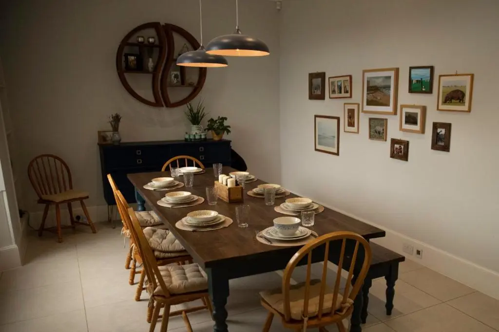 a dining room with a table with chairs and a mirror at The old church house in Inverness