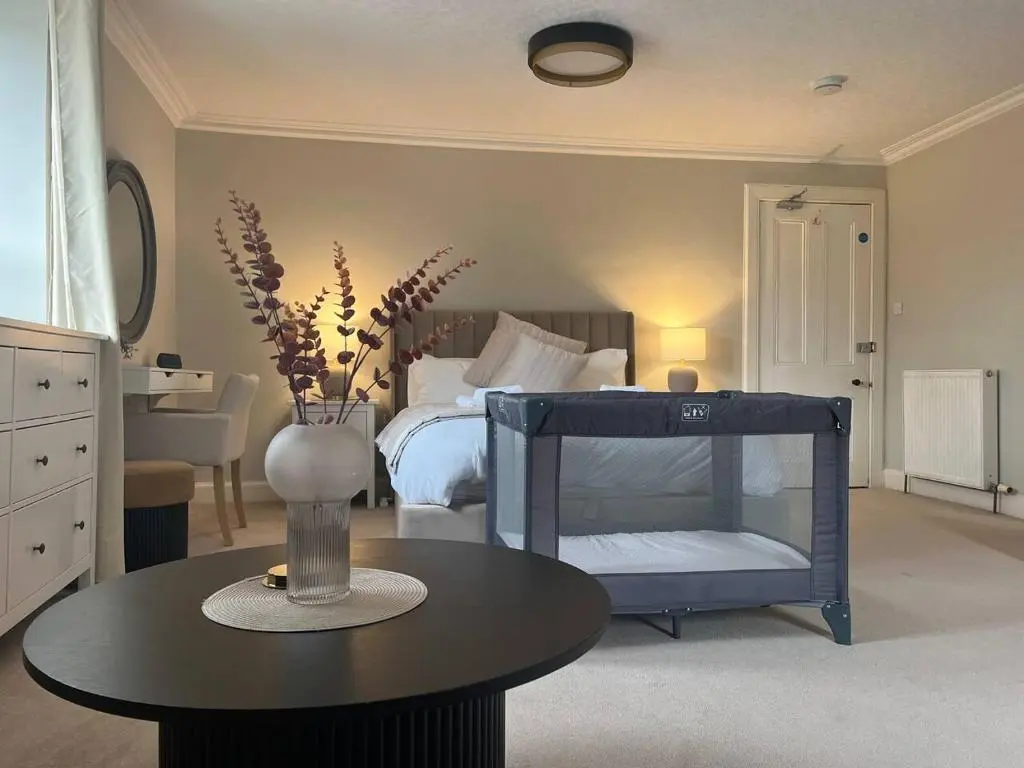 a bedroom with a bed with a vase on a table at Ashley House Contemporary 4 Bedroom Stay for 13 in Inverness