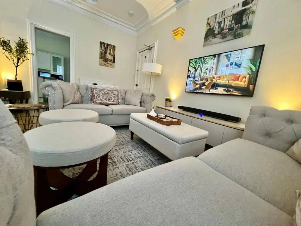 a living room with white furniture and a flat screen tv at Ashley House Contemporary 4 Bedroom Stay for 13 in Inverness