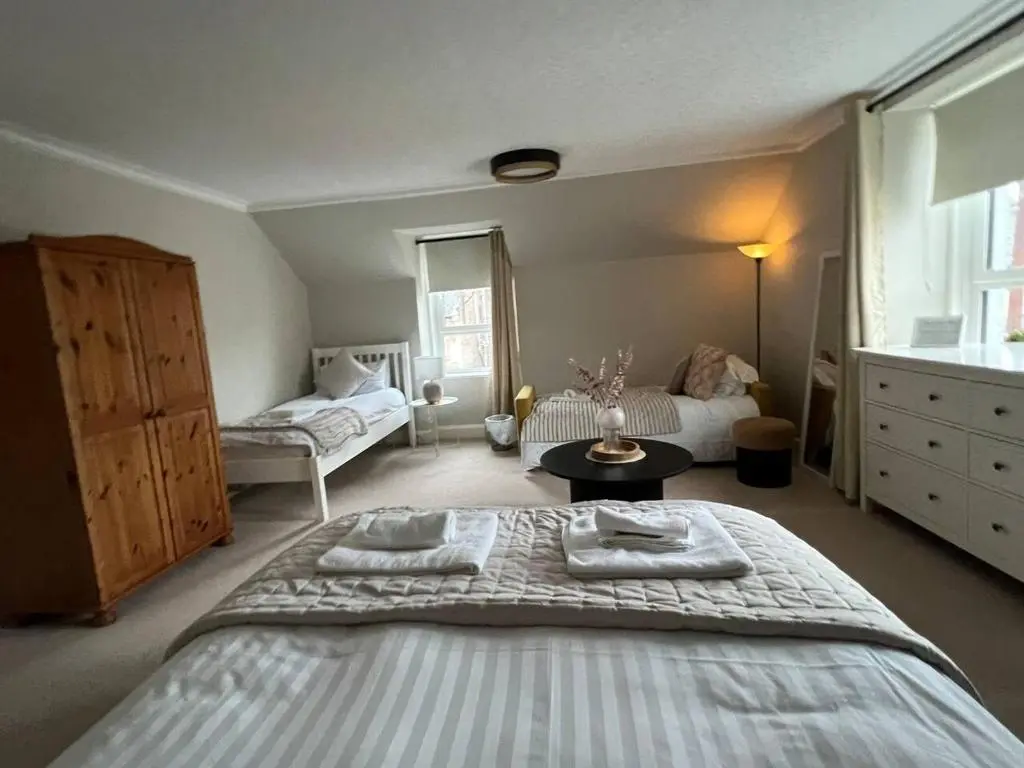 a bedroom with a bed with towels on it at Ashley House Contemporary 4 Bedroom Stay for 13 in Inverness