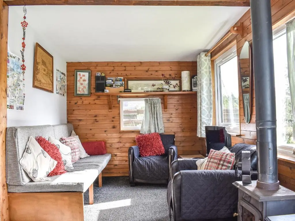 a living room with two couches and a stove at The Chalet - Ukc5786 in Nethy Bridge