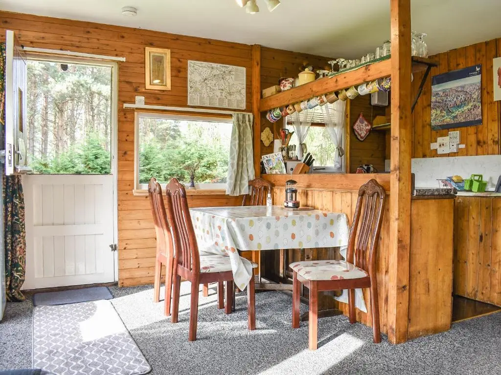 a kitchen with a table and chairs in a room at The Chalet - Ukc5786 in Nethy Bridge