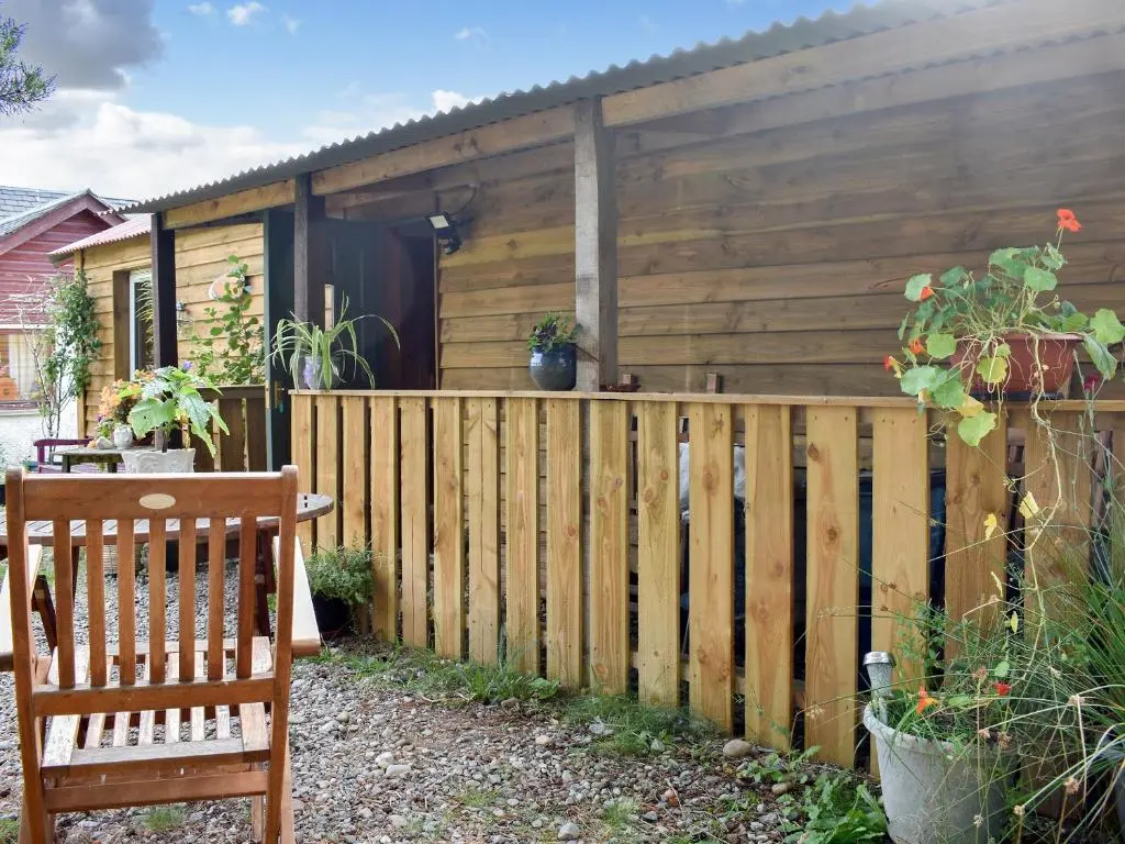 a wooden fence in front of a house at The Bothy - Ukc5785 in Nethy Bridge