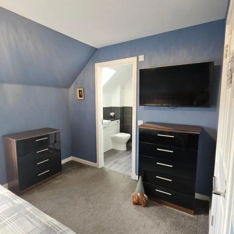 a bedroom with a bed and a bathroom with a toilet at The White House in Elgin