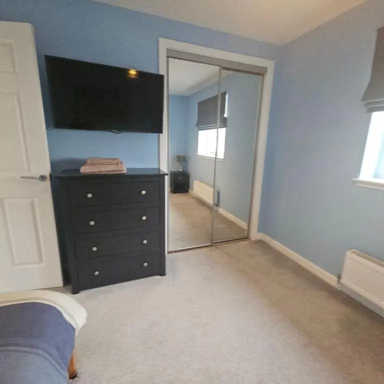 a bedroom with a dresser and a large mirror at The White House in Elgin