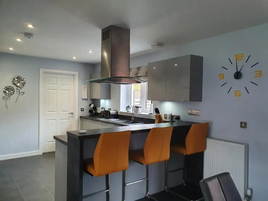 a kitchen with a counter and a clock on the wall at The White House in Elgin