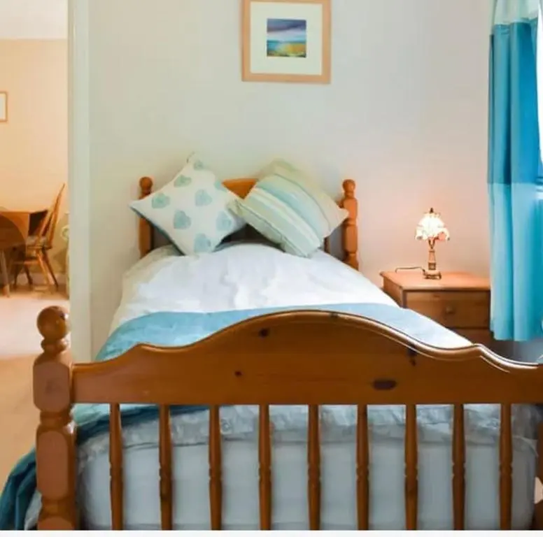 a bedroom with a wooden bed with blue curtains at Drummond Neuk - Pets Welcome free, country setting, free onsite parking in Inverness