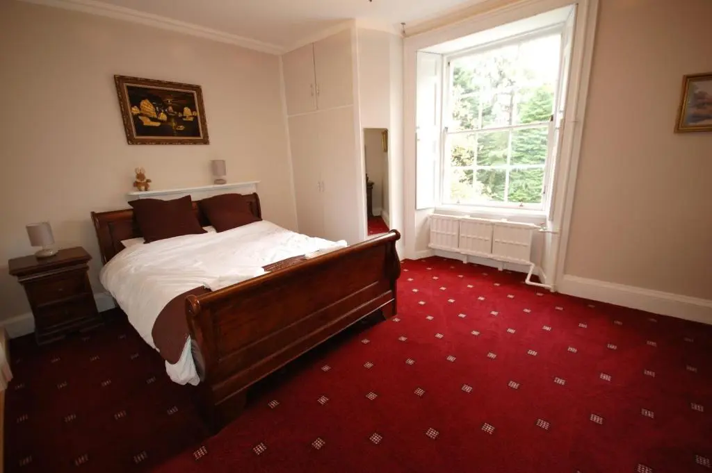 a bedroom with a bed and a large window at The Old Manse, Fochabers in Fochabers
