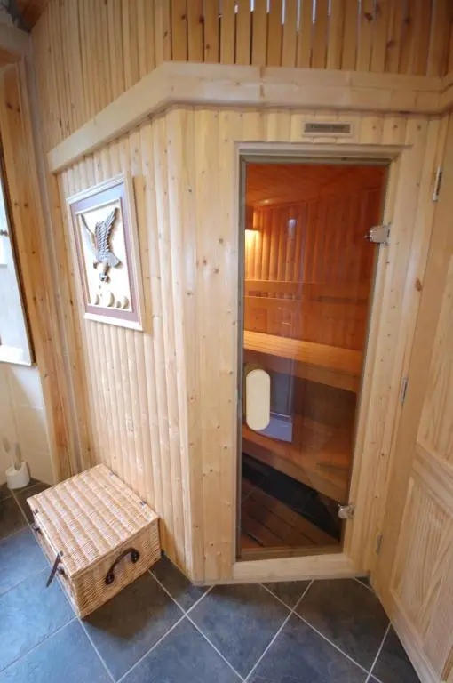 a wooden room with a shower with a bench in it at The Old Manse, Fochabers in Fochabers