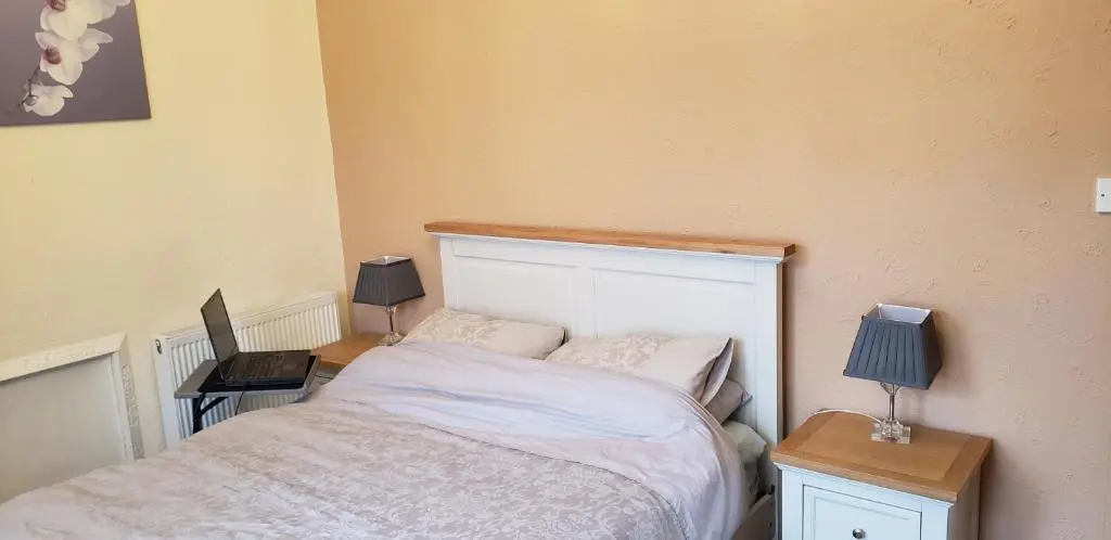 a small bedroom with a bed and two lamps at Jane's Cottage Free Parking in Inverness