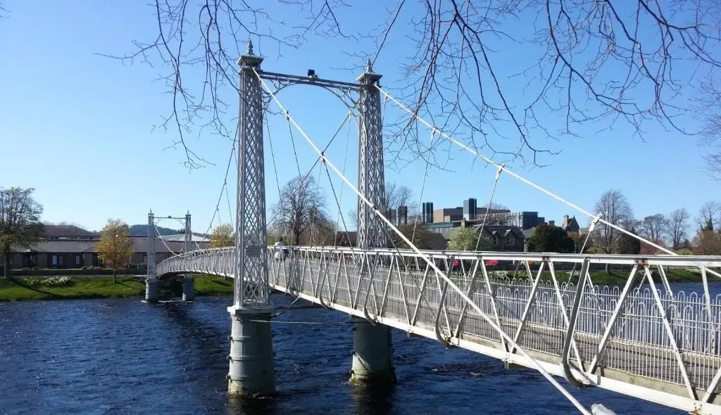 a bridge over a river with a train on it at Jane's Cottage Free Parking in Inverness