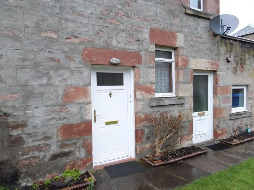 a brick house with a white door and two windows at Jane's Cottage Free Parking in Inverness