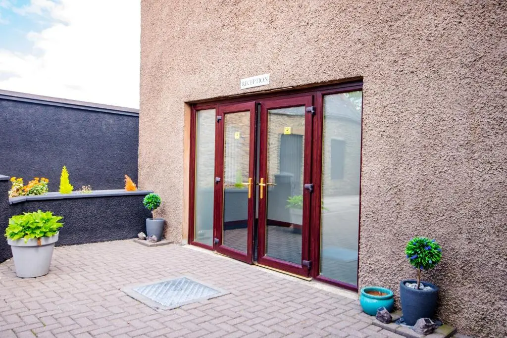 a patio with sliding glass doors and potted plants at Weston House Keith in Keith