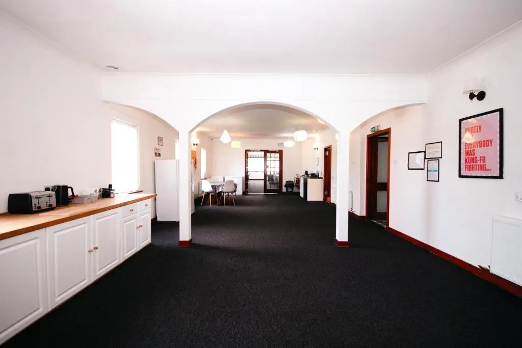 a room with white walls and a hallway with a kitchen at Weston House Keith in Keith