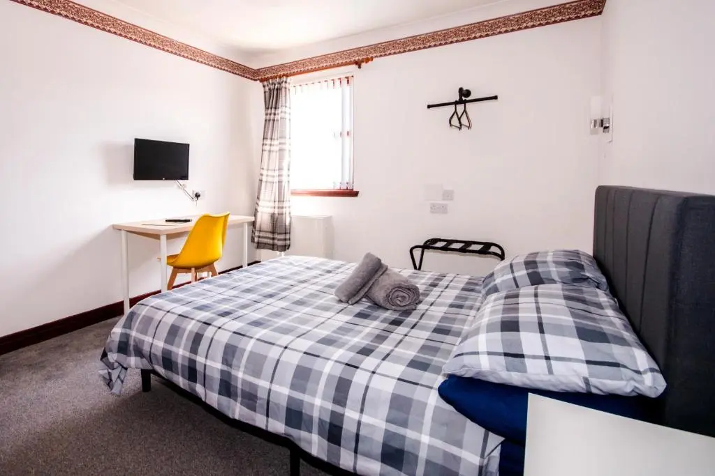 a bedroom with a bed and a desk and a chair at Weston House Keith in Keith