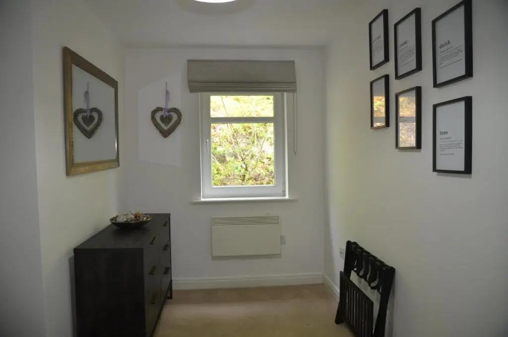 a room with a window and a dresser and some pictures at SCOTTISH HIGHLANDS Superb 2 bedroom apartment. in Invergarry