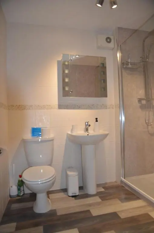 a bathroom with a toilet and a sink and a shower at SCOTTISH HIGHLANDS Superb 2 bedroom apartment. in Invergarry