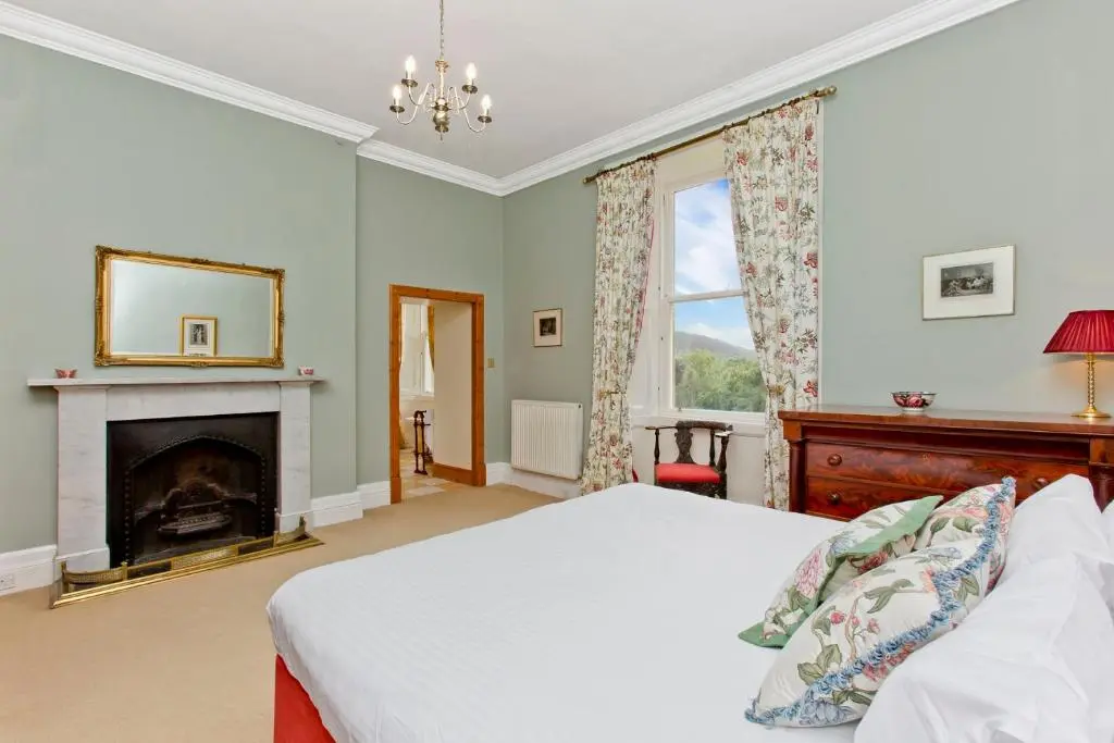 a bedroom with a bed and a fireplace at Dalnaglar Castle in Blairgowrie