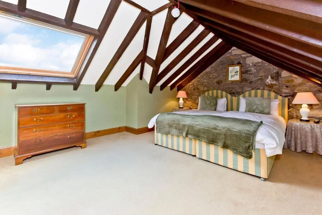 a bedroom with a bed and two windows at Dalnaglar Castle in Blairgowrie