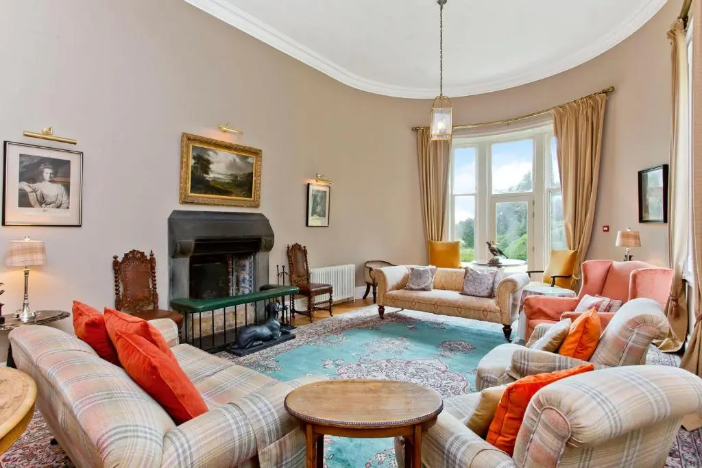 a living room with couches and a fireplace at Dalnaglar Castle in Blairgowrie